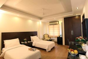 新德里The Legend Inn Delhi的酒店客房配有两张床和一张书桌