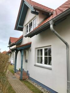 蒂门多夫Ferienhäuser Liethmann Haus 3 W2的白色房子,有红色屋顶