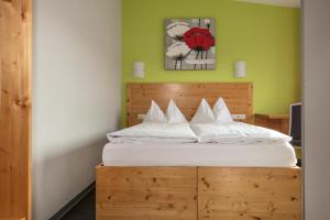 兰德尔萨克尔德姆林酒店-咖啡厅的一间卧室配有一张带木制床头板的床