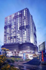 雅加达ASTON Pluit Hotel & Residence的一座白色的大建筑,上面有灯