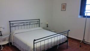 卡尔米尼亚诺弗里吉奥纳亚农家乐的一间卧室配有一张带白色床单的床和一扇窗户。