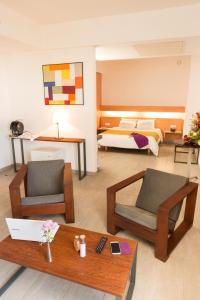 阿比让ONOMO Hotel Abidjan的客厅配有两把椅子和一张床