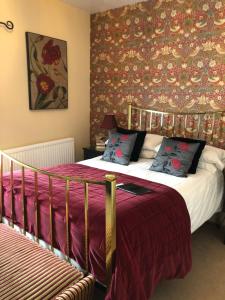 伊斯特布恩The Langtons Bed & Breakfast的一间卧室配有一张红色和金色壁纸的床