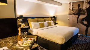 绍斯波特The Vincent Hotel的一间酒店客房,配有一张床和一盘食物