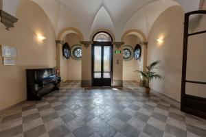 佛罗伦萨拉斯特拉别墅酒店的一个空房间,有门和钢琴