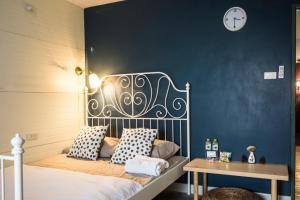 曼谷柳颜笔塾旅舍的一间卧室设有一张床和蓝色的墙壁