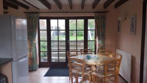 桑顿代尔Sands Farm Cottages的一间带桌椅和窗户的用餐室
