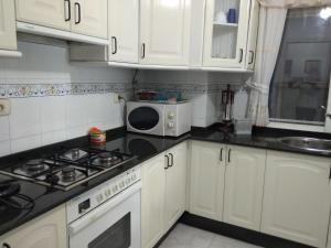 拉科萨Apartamento con vistas en Raxó的厨房配有白色橱柜和微波炉