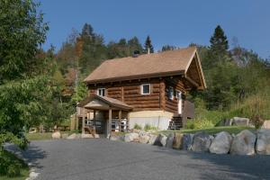 Saint Adolphe D'HowardLe log home - Locations du sommet的小木屋前面设有车道