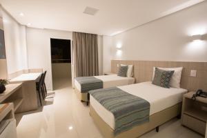 福莫萨Solaris Hotel的酒店客房设有两张床和盥洗盆