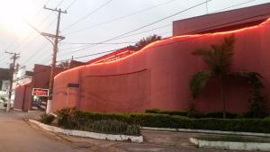 Vila AnastácioAmerica Motel (ADULT ONLY)的一面有灯的红色建筑