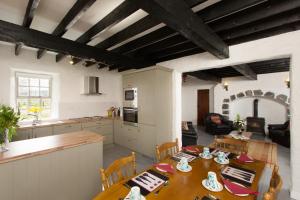 戈尔韦Dunguaire Thatched Cottages的厨房以及带桌椅的用餐室。