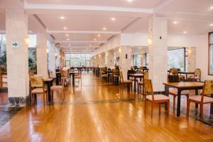 乌鲁班巴巴列萨格拉多塔皮卡拉豪华酒店的餐厅铺有木地板,配有桌椅