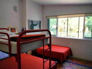 瓜达拉哈拉查普尔特佩克旅舍的一间卧室设有两张双层床和一扇窗户。