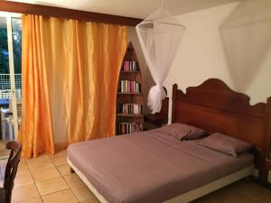 圣安娜Appartement Naïla的一间卧室设有一张床和一个书架