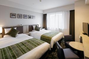 鹿儿岛MYSTAYS 鹿儿岛天文馆酒店的酒店客房设有两张床和电视。