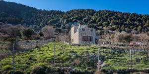 奥马洛斯Omalos Gianni's House的山丘上一座古老的石屋,设有围栏