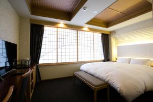 京都京都卡曼扎酒店的酒店客房设有一张大床和窗户。