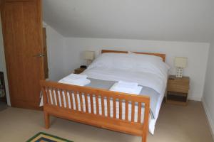耶尔弗顿The Dartmoor Linhay的一间卧室配有白色床单和2个床头柜