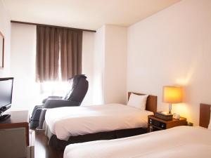 长野亚之杰长野站前酒店的酒店客房,配有两张床和椅子