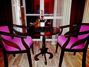 切尔尼戈夫ApartLux 2的一张桌子上摆放着一瓶葡萄酒,还有两把椅子