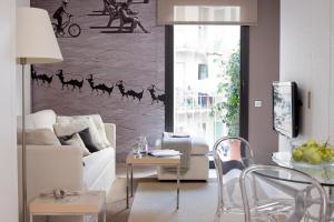 巴塞罗那埃里克维科尔精品公寓 - 圣家堂套房的客厅配有白色沙发,墙上挂着骆驼绘画