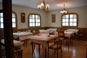 罗德里戈城太阳门旅馆的餐厅设有白色的桌椅和窗户。