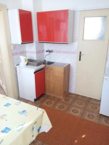 Vyšnie Šuňavachalupy Šuňava的厨房配有红色和白色的橱柜和水槽
