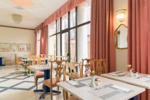 克雷马蓬迪里亚托酒店的餐厅设有桌椅和窗户。