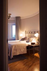 乌普萨拉霍恩格兰德酒店的一间卧室配有一张床和一张带两盏灯的桌子。