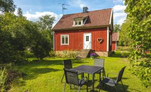 BroddetorpBosgårdens Cottages的红色房子前面的一张桌子和椅子