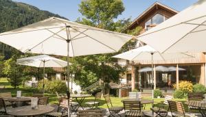 加舒恩Felbermayer Hotel & AlpineSpa-Montafon的一组桌子和伞在建筑前