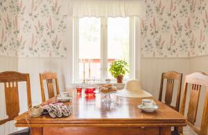 BroddetorpBosgårdens Cottages的一间带木桌和窗户的用餐室