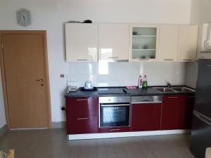 BrijestaHoliday home >Nikola< Brijesta的厨房配有红色橱柜和炉灶烤箱
