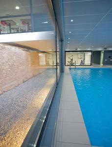 斯特拉斯堡斯特拉斯堡威尔逊拉格朗日公寓式酒店的一座带大型蓝色游泳池的建筑中的游泳池
