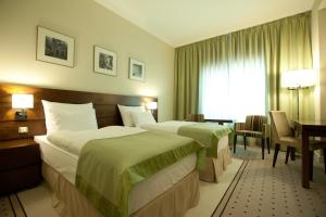 布加勒斯特首府广场酒店的酒店客房配有两张床和一张书桌
