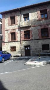 El HornilloCasa Rural Rio Canto的停在砖楼前的蓝色汽车