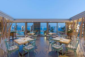 卡利斯托斯Anastasia Hotel & Suites Mediterranean Comfort的阳台餐厅,配有桌椅