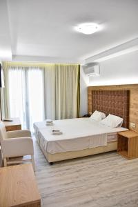 赫索尼索斯阿耳忒弥斯公寓式酒店的一间卧室配有一张大床和一把椅子