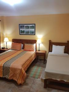 Piarco皮亚尔科乡村住宿加早餐旅馆的一间卧室设有两张床和两张台灯。