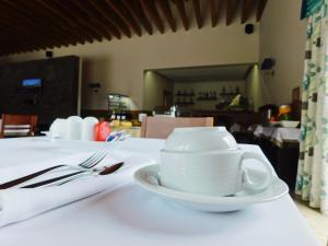 马达莱纳拜亚达巴卡酒店的坐在白色桌子上的白咖啡杯