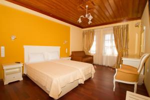 莫诺登德里莫诺登德里酒店的黄色卧室,配有床和椅子