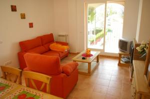萨贡托Apartamentos Concha del Mar的客厅配有橙色沙发和桌子