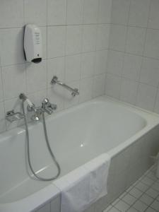 Beuningen弗莱彻丁克洛德餐厅酒店的浴室设有带淋浴的白色浴缸。