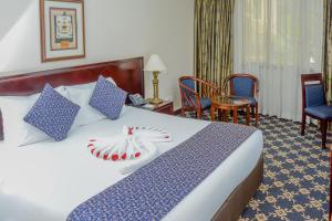 内罗毕内罗毕蓝花楹酒店的酒店的客房 - 带蓝色和白色枕头的床