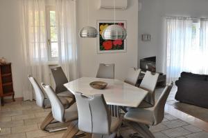 拉齐塞Villa Gasco With Pool的一间配备有白色桌椅的用餐室