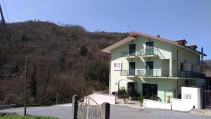 Laino BorgoPalia's Hotel的一座位于山上的白色建筑,设有阳台
