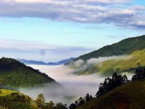 圣弗朗西斯科泽维尔Pousada Serra do Luar的享有树木和山脉的雾 ⁇ 山谷美景