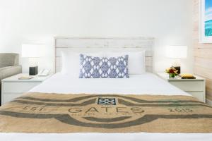 基韦斯特基韦斯特盖茨酒店的卧室配有白色的床和两盏灯。