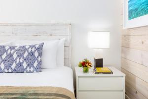 基韦斯特基韦斯特盖茨酒店的一间卧室配有一张床和一个带灯的床头柜
